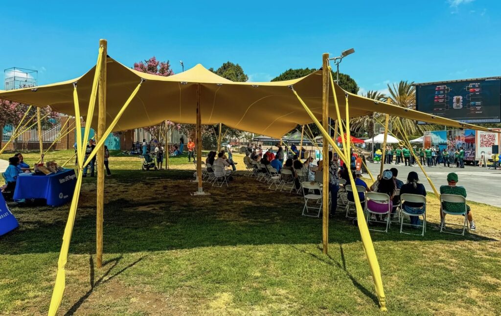 A yellow tend shades a grassy area during a World Cup Watch Party in LA